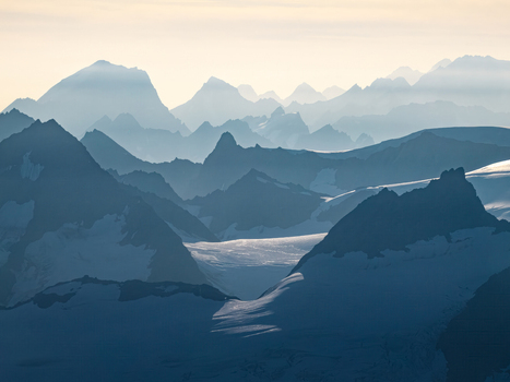 Aerial view of the snow capped peaks and glaciers of Chugach State Park with layered mountain ranges in the soft light of Anchorage Alaska United States. Aerial view of the snow capped peaks and glaciers of Chugach State Park with layered mountain ranges in the soft light of Anchorage Alaska United States.