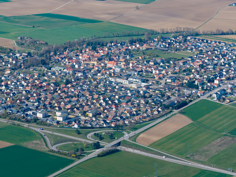Aerial view of a cluster of houses nestled amidst a patchwork of fields the built environment contrasting with the open spaces Sausheim Grand Est France.