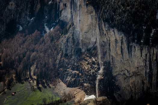 View of cascading waterfalls plunging down sheer rock faces amidst the rugged terrain and lush greenery of the Swiss Alps Lauterbrunnen Switzerland. View of cascading waterfalls plunging down sheer rock faces amidst the rugged terrain and lush greenery of the Swiss Alps Lauterbrunnen Switzerland.