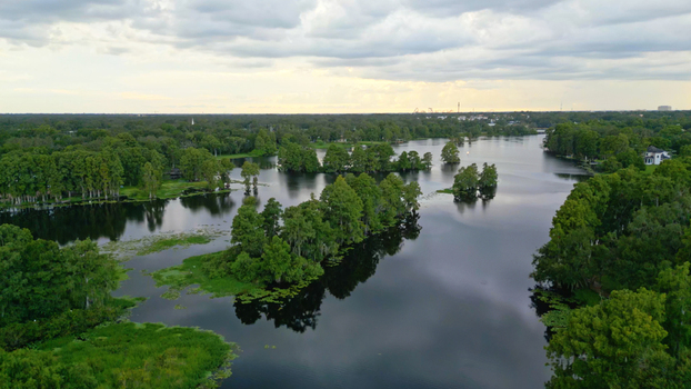 Aerial view of a serene lake surrounded by lush cypress trees and small islands under a cloudy sky in Tampa Florida United States. Aerial view of a serene lake surrounded by lush cypress trees and small islands under a cloudy sky in Tampa Florida United States.