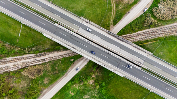 Aerial view of a highway interchange with vehicles cutting through lush green fields a modern intersection of concrete and nature Sremska Mitrovica Vojvodina Serbia. Aerial view of a highway interchange with vehicles cutting through lush green fields a modern intersection of concrete and nature Sremska Mitrovica Vojvodina Serbia.