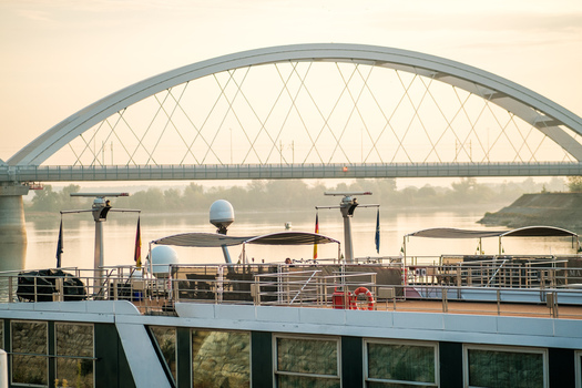View of the Zezelj Bridge over the Danube River with a river cruise ship in the foreground Novi Sad Vojvodina Serbia. View of the Zezelj Bridge over the Danube River with a river cruise ship in the foreground Novi Sad Vojvodina Serbia.