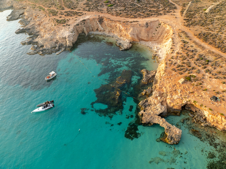 Aerial view of azure waters embracing rugged cliffs and boats near the Blue Lagoon a serene escape on Comino s coast Blue lagoon Comino Malta. Aerial view of azure waters embracing rugged cliffs and boats near the Blue Lagoon a serene escape on Comino s coast Blue lagoon Comino Malta.