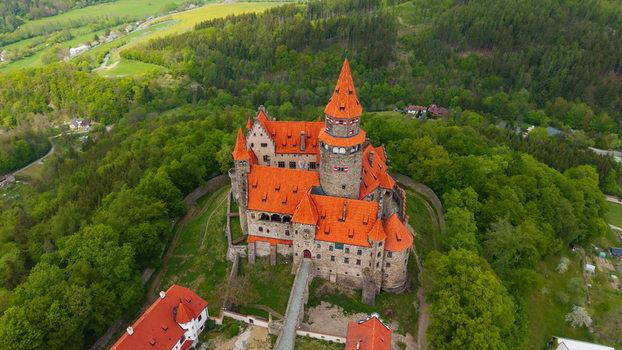 Aerial view of Bouzov Castle with its iconic red tiled roofs and tall tower nestled in a lush green forest Bouzov Olomoucky kraj Czechia. Aerial view of Bouzov Castle with its iconic red tiled roofs and tall tower nestled in a lush green forest Bouzov Olomoucky kraj Czechia.