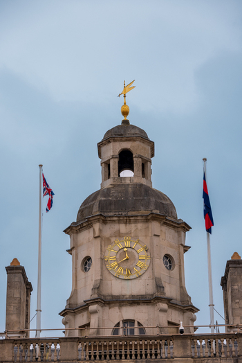 London United Kingdom 12 May 2025 View of the historic Horse Guards building clock tower featuring a golden clock face and weather vane under an overcast sky.