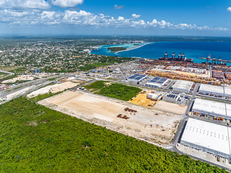 Aerial view of DP World Dominicana port facility with shipping containers industrial warehouses and coastal landscape in Boca Chica Santo Domingo Dominican Republic. Aerial view of DP World Dominicana port facility with shipping containers industrial warehouses and coastal landscape in Boca Chica Santo Domingo Dominican Republic.