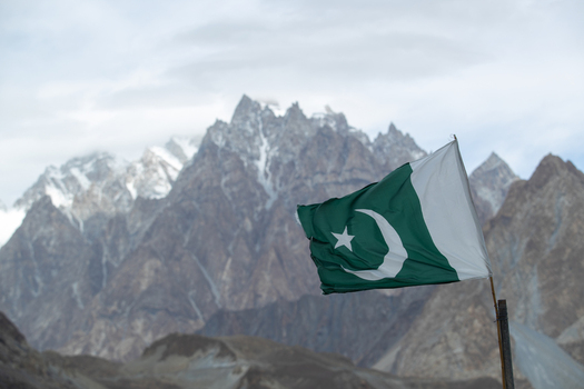View of the Pakistani flag waving against the backdrop of the majestic Passu Cones mountain range in Passu Gilgit Pakistan. View of the Pakistani flag waving against the backdrop of the majestic Passu Cones mountain range in Passu Gilgit Pakistan.