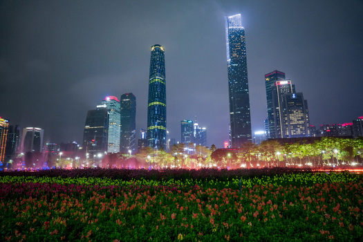 Guangzhou Guangdong Province China 24 February 2024 View of the illuminated skyline of Zhujiang New Town rising above the vibrant flower beds of Huacheng Square at night. Guangzhou Guangdong Province China 24 February 2024 View of the illuminated skyline of Zhujiang New Town rising above the vibrant flower beds of Huacheng Square at night.