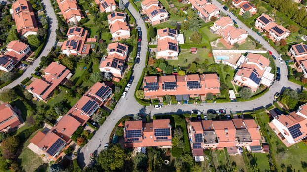 Aerial view of modern Italian homes with solar panels on red tiled roofs and lush private gardens in a residential neighborhood in Milan Lombardy Italy. Aerial view of modern Italian homes with solar panels on red tiled roofs and lush private gardens in a residential neighborhood in Milan Lombardy Italy.