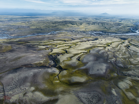 Aerial view of the volcanic landscape of Eldgja with moss covered lava fields winding rivers and distant mountains in Kirkjubaejarklaustur Skaftarhreppur Iceland. Aerial view of the volcanic landscape of Eldgja with moss covered lava fields winding rivers and distant mountains in Kirkjubaejarklaustur Skaftarhreppur Iceland.