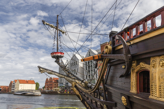 Gdansk Pomeranian Voivodeship Poland 07 September 2026 View of a historic galleon ship replica with ornate wooden hull and golden carvings docked on the Motlawa River. Gdansk Pomeranian Voivodeship Poland 07 September 2026 View of a historic galleon ship replica with ornate wooden hull and golden carvings docked on the Motlawa River.