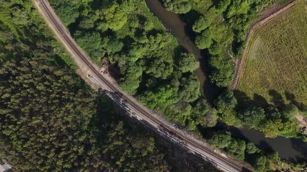 Aerial view of train carrying shipping containers and river Portugal.