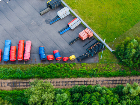 Aerial view of pipe manufacturing facility with stacks of colorful polymer pipes stored in an industrial yard near railway tracks in Jelgava Latvia. Aerial view of pipe manufacturing facility with stacks of colorful polymer pipes stored in an industrial yard near railway tracks in Jelgava Latvia.