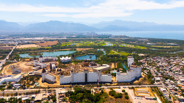 Aerial view of an elaborate castle like structure nestled amidst a vibrant landscape of green fields and winding waterways Riviera Nayarit Mexico
