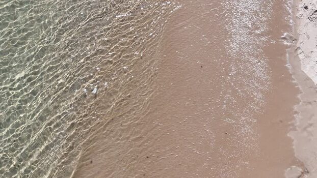 Aerial view of gentle waves washing onto a sandy beach Portugal. Aerial view of gentle waves washing onto a sandy beach Portugal.