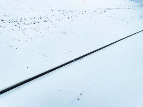 Aerial view of a lonely road stretching through a vast snow covered landscape in Egilsstadir Mulathing Iceland. Aerial view of a lonely road stretching through a vast snow covered landscape in Egilsstadir Mulathing Iceland.