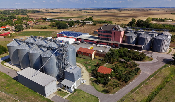 Aerial view of the Silo Bavaniste grain storage facility featuring large metal silos industrial buildings with solar panels and surrounding agricultural fields in Bavaniste Vojvodina Serbia.