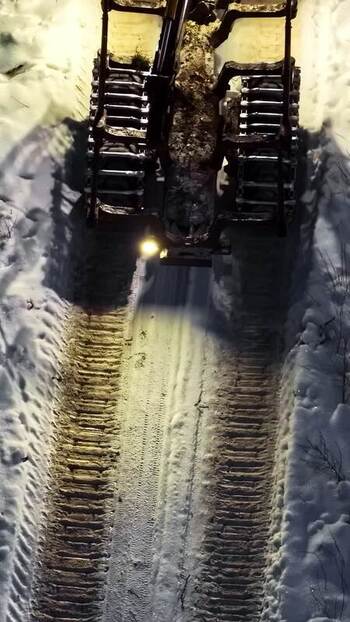 Aerial view of forestry machine in snowy forest Latvia.