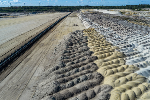 Aerial view of Tagebau Welzow Sud brown coal open pit mine with large conveyor belt systems vast excavated earth and textured soil mounds in Spremberg Brandenburg Germany. Aerial view of Tagebau Welzow Sud brown coal open pit mine with large conveyor belt systems vast excavated earth and textured soil mounds in Spremberg Brandenburg Germany.