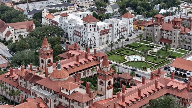Aerial view of the historic Lightner Museum and Flagler College campus featuring Spanish Renaissance architecture terracotta roofs and manicured gardens in St. Augustine Florida United States. Aerial view of the historic Lightner Museum and Flagler College campus featuring Spanish Renaissance architecture terracotta roofs and manicured gardens in St. Augustine Florida United States.