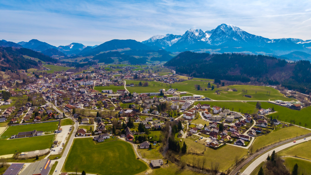 Aerial view of the charming Windischgarsten valley nestled amidst rolling green hills with the majestic snow capped Alps piercing the horizon Windischgarsten Upper Austria Austria. Aerial view of the charming Windischgarsten valley nestled amidst rolling green hills with the majestic snow capped Alps piercing the horizon Windischgarsten Upper Austria Austria.