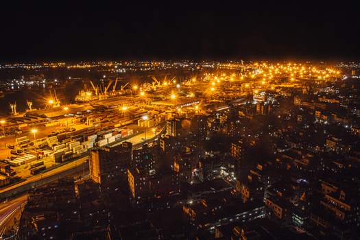 Chittagong Bangladesh 01 September 2021 Aerial view of Chattogram Port at night featuring illuminated shipping containers cranes and the surrounding urban landscape.