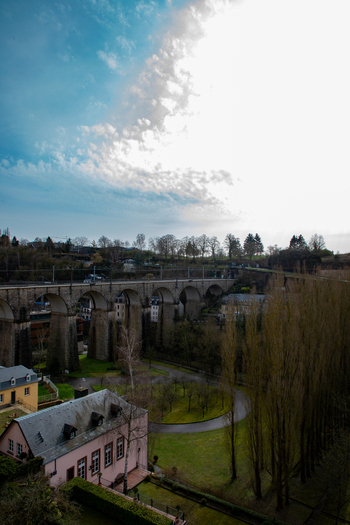 Aerial view of the historic Passerelle viaduct spanning the valley with stone arches lush green parkland and surrounding urban architecture in Luxembourg Luxembourg Luxembourg.