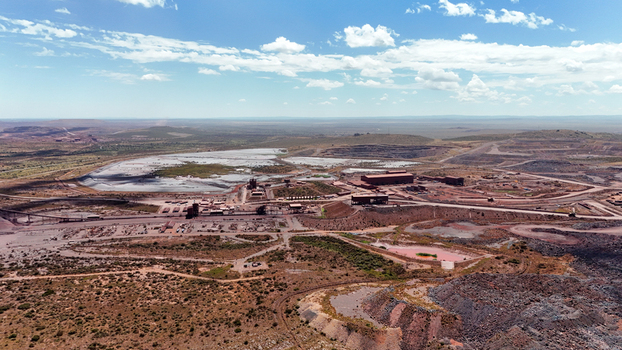 Aerial view of a sprawling industrial mining complex with vast reddish brown earth and shimmering water bodies under a clear sky Rustenburg North West South Africa. Aerial view of a sprawling industrial mining complex with vast reddish brown earth and shimmering water bodies under a clear sky Rustenburg North West South Africa.