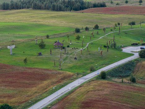Aerial view of the Hill of Angels featuring numerous wooden sculptures scattered across green meadows and rolling hills in Traku rajonas Vilniaus apskritis Lithuania. Aerial view of the Hill of Angels featuring numerous wooden sculptures scattered across green meadows and rolling hills in Traku rajonas Vilniaus apskritis Lithuania.