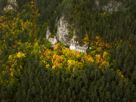 Aerial view of a monastery nestled amid the vibrant autumnal colors of the forest contrasting with the gray rock formations Mende Occitanie France. Aerial view of a monastery nestled amid the vibrant autumnal colors of the forest contrasting with the gray rock formations Mende Occitanie France.
