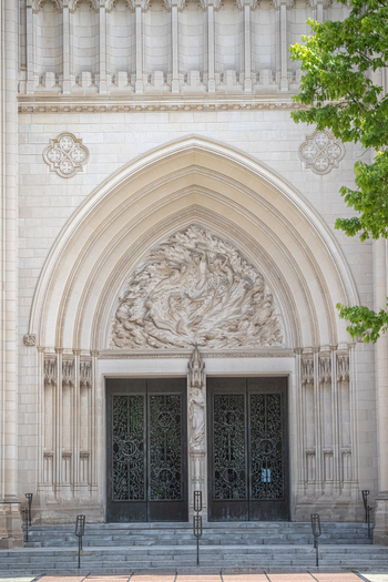 Washington District of Columbia United States 06 May 2025 View of Washington National Cathedral with intricate stone carvings detailed tympanum and ornate metal doors.