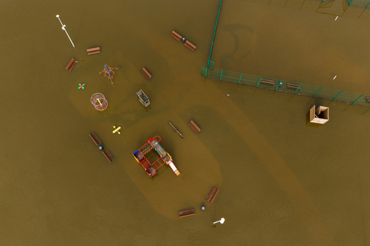 Aerial view of a flooded children s playground with colorful equipment and benches partially submerged in brown water Kedainiai Kaunas County Lithuania. Aerial view of a flooded children s playground with colorful equipment and benches partially submerged in brown water Kedainiai Kaunas County Lithuania.
