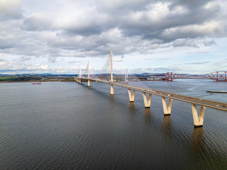 Aerial view of the Queensferry Crossing bridge spanning the Firth of Forth with the historic Forth Bridge in the background South Queensferry United Kingdom.