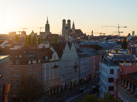 Aerial view of the historic skyline featuring the Frauenkirche and St. Peter s Church during golden hour with construction cranes in the distance in Munich Bavaria Germany. Aerial view of the historic skyline featuring the Frauenkirche and St. Peter s Church during golden hour with construction cranes in the distance in Munich Bavaria Germany.