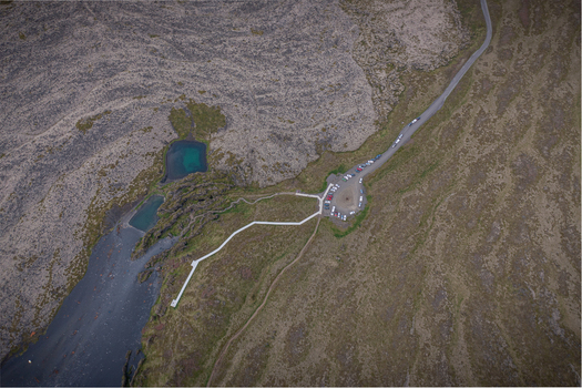 Aerial view of Djupalonssandur featuring a parking area walking paths and volcanic rock formations in Iceland. Aerial view of Djupalonssandur featuring a parking area walking paths and volcanic rock formations in Iceland.