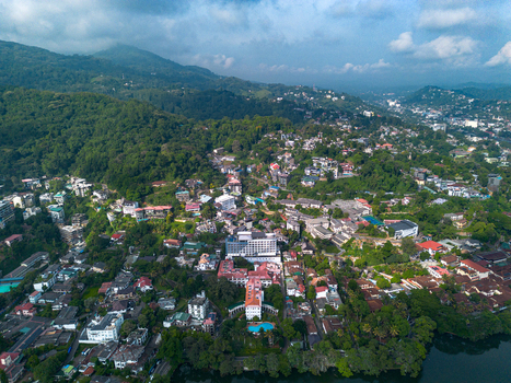 Aerial view of Kandy Lake surrounded by lush green hills dense urban development and historic buildings in Kandy Central Province Sri Lanka. Aerial view of Kandy Lake surrounded by lush green hills dense urban development and historic buildings in Kandy Central Province Sri Lanka.
