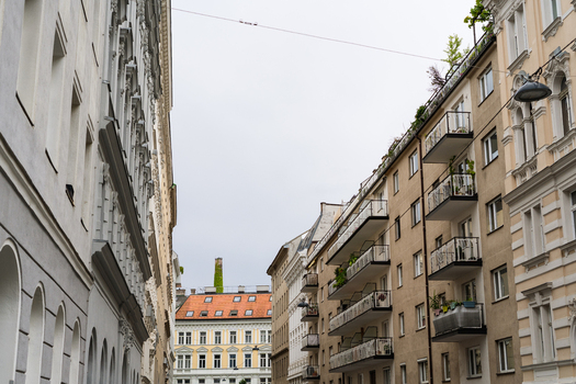 View of a narrow street flanked by historic and modern apartment buildings with balconies and ornate facades Vienna Vienna Austria. View of a narrow street flanked by historic and modern apartment buildings with balconies and ornate facades Vienna Vienna Austria.