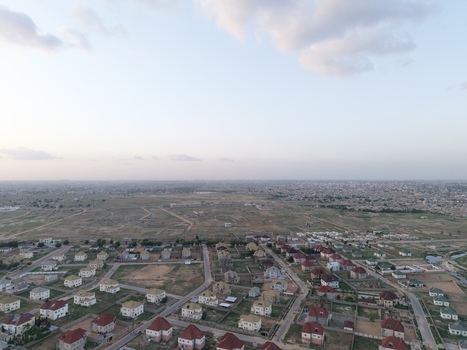 Aerial view of modern residential houses with red roofs and a grid street layout overlooking the vast urban landscape of Kano City Kano Nigeria.