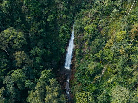 Aerial view of Khun Korn Waterfall cascading down a cliff into a rocky pool surrounded by dense tropical rainforest in Tambon Huai Chomphu Chang Wat Chiang Rai Thailand. Aerial view of Khun Korn Waterfall cascading down a cliff into a rocky pool surrounded by dense tropical rainforest in Tambon Huai Chomphu Chang Wat Chiang Rai Thailand.