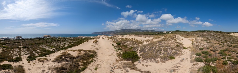 Aerial view of Praia do Guincho with its expansive sand dunes coastal vegetation and the Atlantic Ocean under a clear blue sky in Cascais Lisbon Portugal. Aerial view of Praia do Guincho with its expansive sand dunes coastal vegetation and the Atlantic Ocean under a clear blue sky in Cascais Lisbon Portugal.