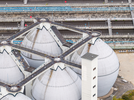 Aerial view of the Klarwerk Ruhleben sewage treatment plant with large white digester tanks and connecting walkways in Berlin Berlin Germany.