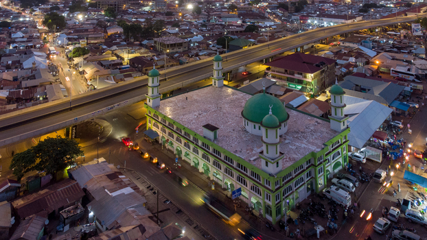 Aerial view of Tamale Central Mosque with its green dome and minarets illuminated at night situated near an elevated highway in Tamale Northern Region Ghana. Aerial view of Tamale Central Mosque with its green dome and minarets illuminated at night situated near an elevated highway in Tamale Northern Region Ghana.
