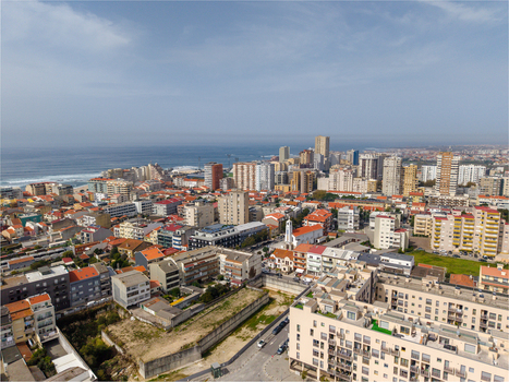 Aerial view of Igreja de Nossa Senhora do Desterro amidst dense urban cityscape red tiled rooftops and buildings overlooking the Atlantic Ocean in Povoa de Varzim Porto Portugal. Aerial view of Igreja de Nossa Senhora do Desterro amidst dense urban cityscape red tiled rooftops and buildings overlooking the Atlantic Ocean in Povoa de Varzim Porto Portugal.