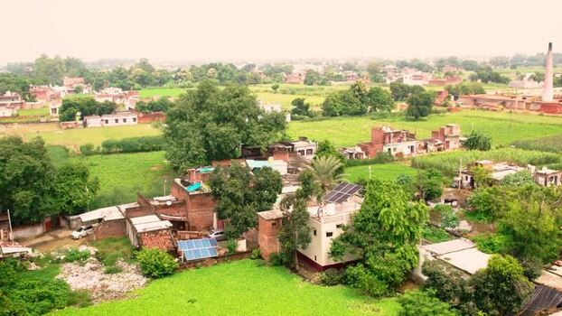 Aerial view of solar panels on village rooftops in India.