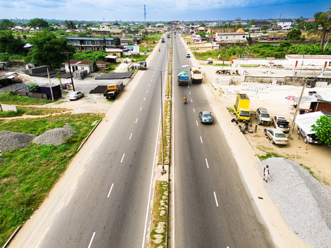 Aerial view of a multi lane highway with vehicles passing through an urban area with lush greenery and low rise buildings Port Harcourt Rivers Nigeria. Aerial view of a multi lane highway with vehicles passing through an urban area with lush greenery and low rise buildings Port Harcourt Rivers Nigeria.