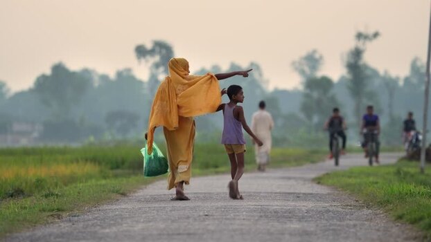 View of a woman and child walking on a rural road in Bangladesh.