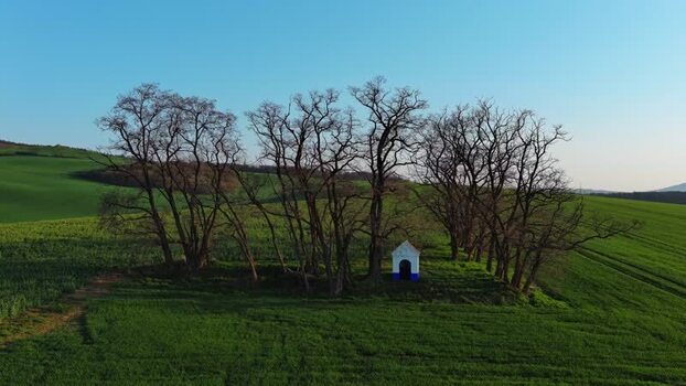 Aerial view of a small chapel in a green field Czechia.