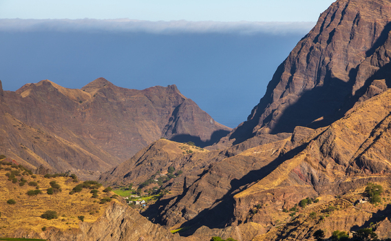 Aerial view of the rugged volcanic mountains of Santo Antao featuring steep rocky slopes deep valleys and sparse vegetation under clear skies in Alto Mira Porto Novo Cabo Verde.