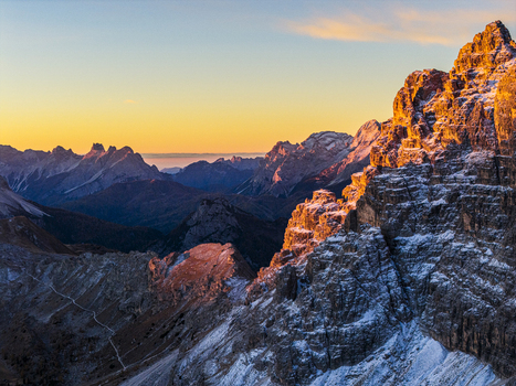 Aerial view of rugged sun kissed Cima di Ambrizzola peak pierce the skyline as shadows dance in the valleys showcasing nature s grandeur Cortina d Ampezzo Veneto Italy.
