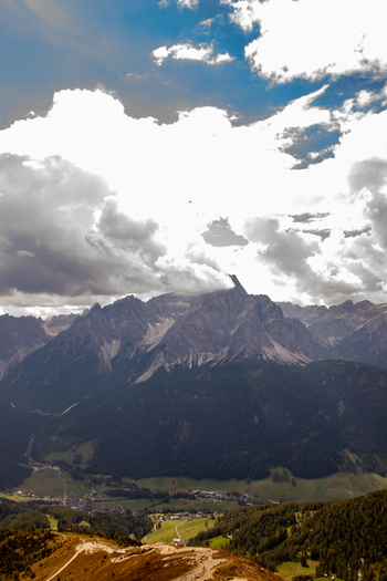 View of the majestic Dolomites mountain peaks under a cloudy sky overlooking the valley and village of Rocca Pietore Veneto Italy. View of the majestic Dolomites mountain peaks under a cloudy sky overlooking the valley and village of Rocca Pietore Veneto Italy.